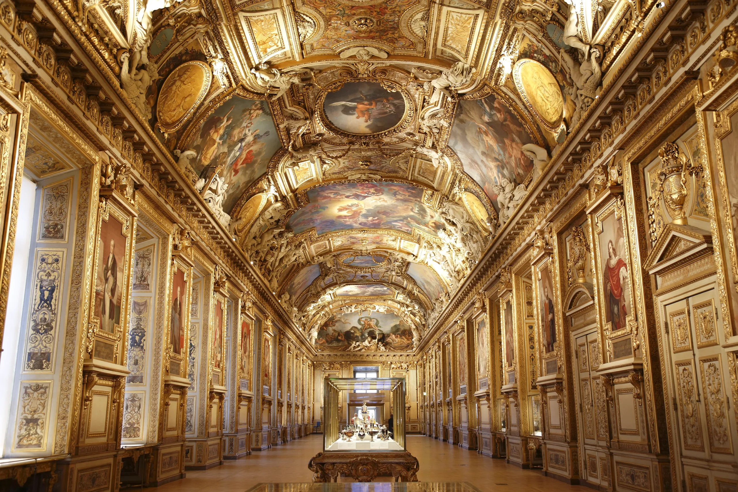 Vue d’une salle d’exposition avec des arcades au Louvre, présentant une galerie de peintures françaises du XIXe siècle.