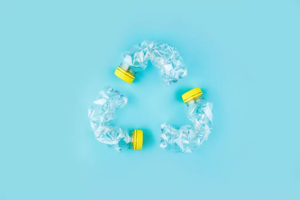 Bouteilles en plastique compressées formant le symbole du recyclage.